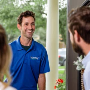 A bluefrog plumber greeting a homeowner at the door